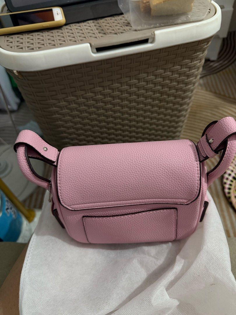 Pink HOLB TREASURE 18 cm (Category: Shoulder Bags) located in Trece Martires City. Submitted by king2318 (Listing ID 1465216401, Image 2). Description: - Color: Light pink - Material: Textured faux leather - Closure: Flap top with silver metal clasp - Strap: Adjustable with side buckle details - Storage: Includes a back slip pocket and clean interior - Size: Compact, ideal for daily carry.