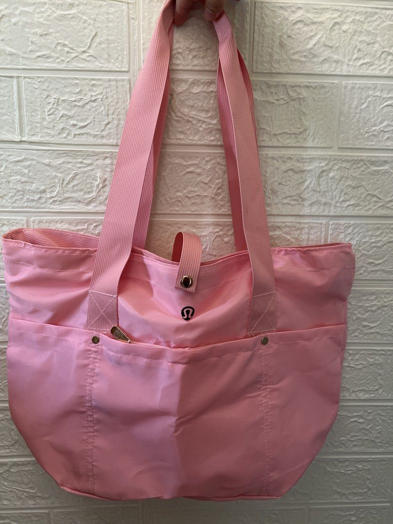 Pink Nylon Tote Bag (Category: Tote Bags) located in Manila. Submitted by go.kluttery (Listing ID 1465230898, Image 1). Description: - Lululemon bright pink tote bag - Durable nylon material with sturdy pink shoulder straps - Secure zipper closure for the main compartment plus top snap strap - Exterior front zipper pocket with classic Lululemon logo emblem .