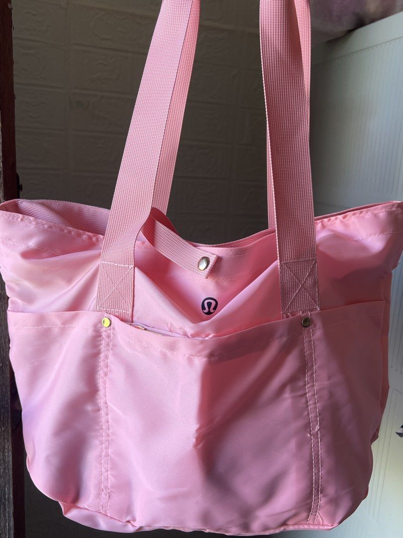 Pink Nylon Tote Bag (Category: Tote Bags) located in Manila. Submitted by go.kluttery (Listing ID 1465230898, Image 3). Description: - Lululemon bright pink tote bag - Durable nylon material with sturdy pink shoulder straps - Secure zipper closure for the main compartment plus top snap strap - Exterior front zipper pocket with classic Lululemon logo emblem .
