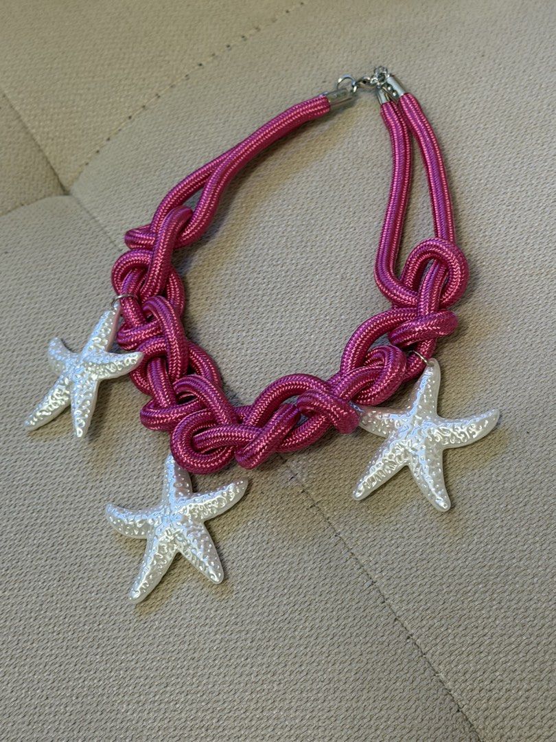 Pink Rope Statement Necklace with White Starfish Charms (Category: Necklaces) located in Pasig City. Submitted by miss_abuelita (Listing ID 1465259720, Image 3). Description: - Style: Chunky nautical statement necklace - Design: Bright pink braided rope with 3 textured white starfish charms - Closure: Secure silver-tone clasp at the back - Comfort: Lightweight and easy to wear all day - Perfect for: Summer outfits, beach trips, and tropical vacat