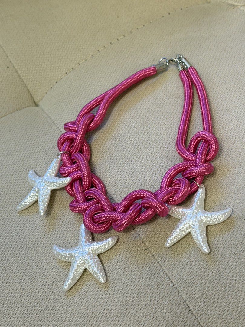 Pink Rope Statement Necklace with White Starfish Charms (Category: Necklaces) located in Pasig City. Submitted by miss_abuelita (Listing ID 1465259720, Image 2). Description: - Style: Chunky nautical statement necklace - Design: Bright pink braided rope with 3 textured white starfish charms - Closure: Secure silver-tone clasp at the back - Comfort: Lightweight and easy to wear all day - Perfect for: Summer outfits, beach trips, and tropical vacat