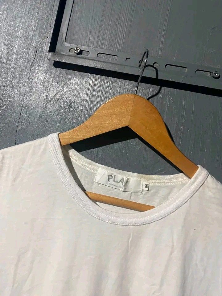 PLAY Comme des Garçons White Tee Size M (Category: Shirts) located in Manila. Submitted by bright.mayess (Listing ID 1465373375, Image 3). Description: - Brand: PLAY Comme des Garçons - Color: White - Size: Medium - Material: 100% Cotton, Made in Japan - Design: Classic red heart embroidery on left chest and big black PLAY logo printed on the back - Fit: Standard crew neck cut - Condition: Clean all around.