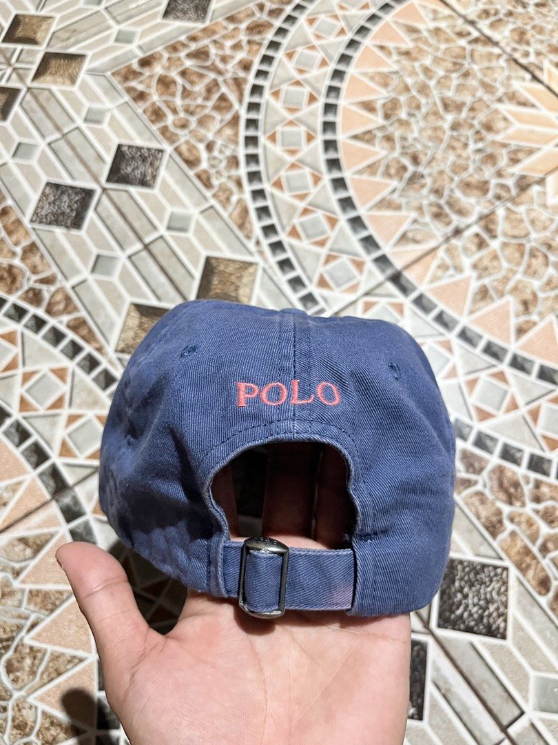 Polo Ralph Lauren Blue Cap (Category: Caps & Hats) located in Puerto Princesa. Submitted by dijaydj28 (Listing ID 1465328105, Image 2). Description: Blue Polo Ralph Lauren baseball cap. Pink embroidered pony logo on the front. 'POLO' stitched in pink above the back strap. Metal slider buckle closure for adjustable fit. Interior label with Polo Ralph Lauren branding. Casual everyday hat, classic style..