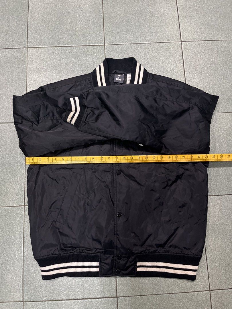 Pony Black Varsity Bomber Jacket Size L (Category: Coats, Jackets and Outerwear) located in Manila. Submitted by dailygetup (Listing ID 1465326298, Image 3). Description: - Brand: Pony - Color: Black - Size: L (Measures 27" across chest, 30" in length) - Material: 100% nylon outer with polyester lining - Closure: Snap button - Details: Striped ribbed collar, cuffs, and hem with embroidered white crest patch on the chest - Fit: Standard fit, ideal