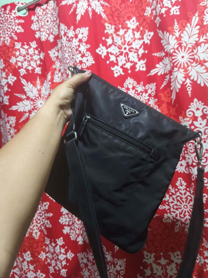 Prada Black Nylon Crossbody Bag (Category: Luxury Bags & Wallets) located in Pasig City. Submitted by pingsrarefinds (Listing ID 1465252961, Image 1). Description: - Authentic black Prada crossbody bag made from durable nylon - Convenient exterior front zip pocket and secure top zipper closure - Adjustable black shoulder strap with sleek silver-tone hardware - Signature Prada jacquard fabric interior lining - Practical inner zip pocket with iconi