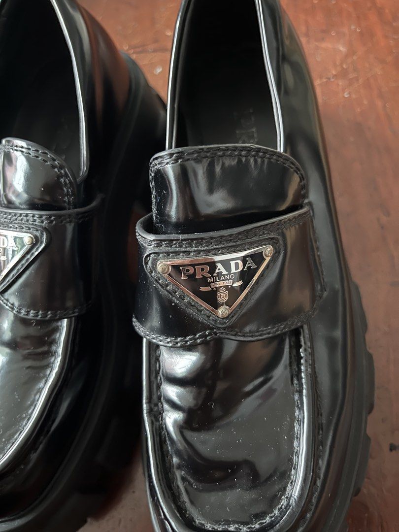 Prada Brushed Leather Monolith Loafers Black (Category: Loafers) located in Manila. Submitted by dailygetup (Listing ID 1465330493, Image 2). Description: - Brand: Prada - Model: Monolith Brushed Leather Loafers - Color: Black - Features: Iconic enamel triangle logo, chunky lug sole, embossed logo on heel and tread, slip-on design - Condition: Excellent pre-loved condition with minimal creasing on the vamp - Inlining: Prada silver lettering stamp