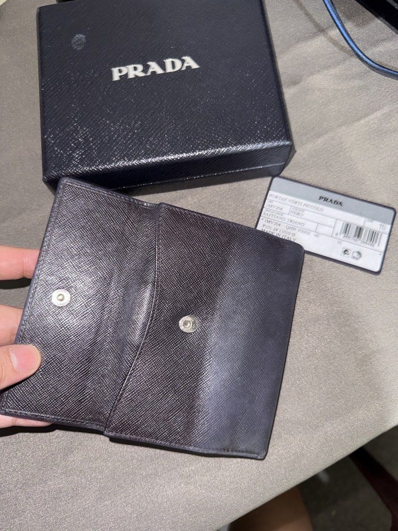 Prada wallet (Category: Wallets & Card holders) located in Caloocan City. Submitted by rossvault2 (Listing ID 1465227058, Image 3). Description: - 100% Authentic Prada compact wallet in Nero Saffiano leather - Iconic enamel triangle logo plaque on the front flap - Secure snap button closure - Features multiple card slots and a spacious cash compartment - Crafted in Italy - Comes complete with original Prada box and authenticity card - Condition: 