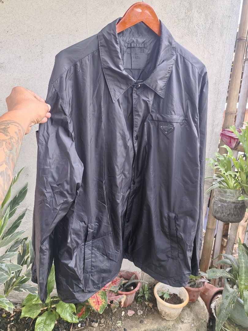 Prada windbreaker button down (Category: Luxury Apparel) located in Iloilo. Submitted by luxury.ilo1984 (Listing ID 1465295118, Image 1). Description: Thrifted Ukay Source Almost new condition No issue 10/10 color rate & conditions Size 54 on tag Dimes 24by30 Best fit large to XL Black colorway.