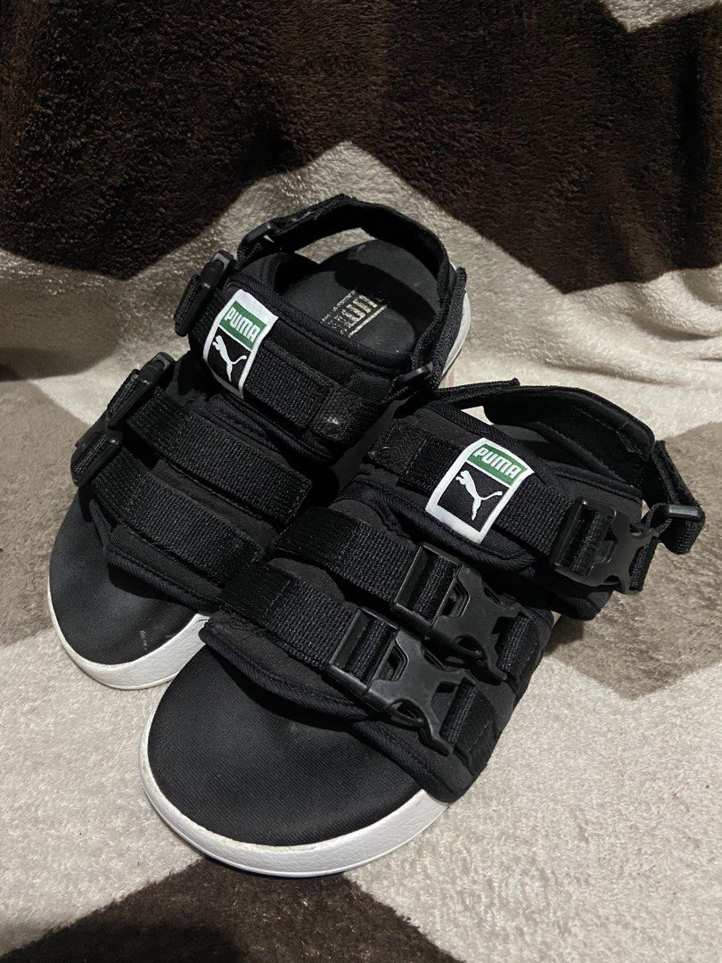 Puma Black Platform Sandals Buckle Straps (Category: Flats & Sandals) located in Manila. Submitted by kiyanna.preloved (Listing ID 1465362030, Image 1). Description: - Brand: Puma - Color: Black with thick white midsole - Size: UK 4.5 / EUR 37 - Features: Secure buckle straps, adjustable velcro, and classic green/white Puma logo patch - Branding: Embossed Puma logo on the side midsole - Style: Comfortable platform sandals perfect for daily wear a