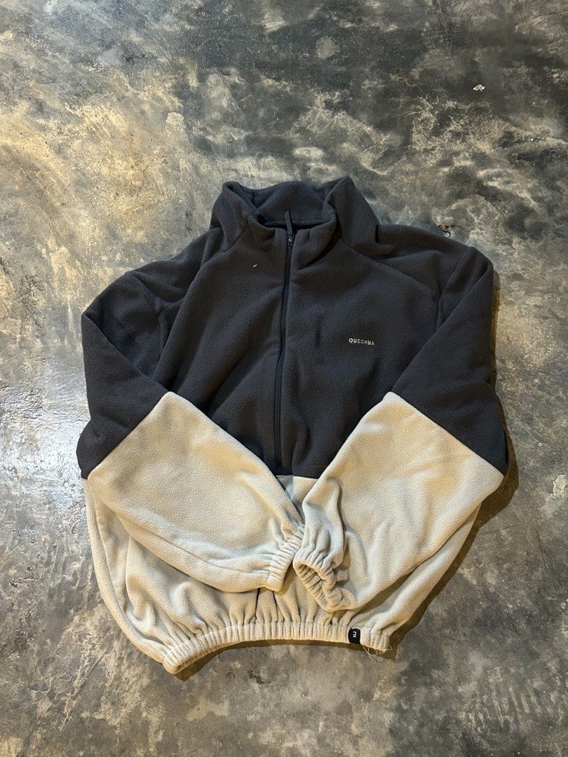 Quechua Two-Tone Fleece Jacket (Category: Coats, Jackets and Outerwear) located in Surigao. Submitted by chastnavarrete (Listing ID 1465275919, Image 1). Description: - Brand: Quechua - Design: Two-tone dark grey top with light grey sleeves and hem - Features: Half-zip front, elasticated cuffs, and bottom hem for a snug fit - Details: Small printed Quechua logo on the left chest - Material: Soft, warm, and cozy fabric - Best For: Outdoor trips, h