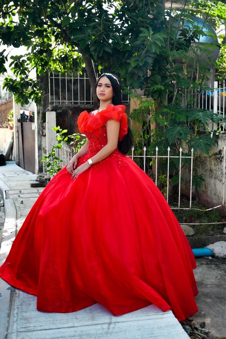 Red ball gown with ruffles and beading (Category: Evening dresses & gowns) located in Manila. Submitted by lindsayleiramse (Listing ID 1465215134, Image 1). Description: - Color: Vibrant red - Length: Floor-length with a very full skirt - Details: Intricate beadwork and floral appliques on the bodice - Sleeves: Statement ruffled off-shoulder in matching sheer red fabric - Condition: Worn once, very clean with no tears or loose beads Ready for deb