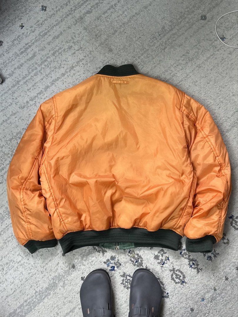 Reversible MA-1 Style Flight Jacket (Category: Coats, Jackets and Outerwear) located in Daet. Submitted by thrifthings2018 (Listing ID 1465218295, Image 3). Description: - Style: MA-1 flight jacket - Color: Sage green (reversible to bright orange) - Details: F-4EJ Phantom II chest patch, sleeve utility pocket with zipper and pen slots - Trim: Ribbed collar, cuffs, and hem - Measurements: Width 26 inches, Length 26 inches - Origin: Made in China w