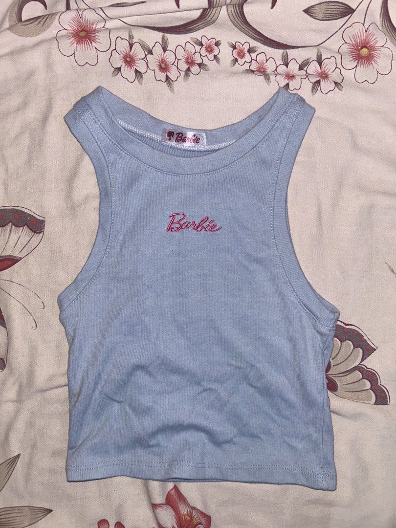 Ribbed crop top tank (Category: Sleeveless) located in Mandaluyong City. Submitted by mariamadeline (Listing ID 1465341240, Image 1). Description: - Color: Light blue with pink Barbie logo embroidery - With minimal stains but unnoticeable .