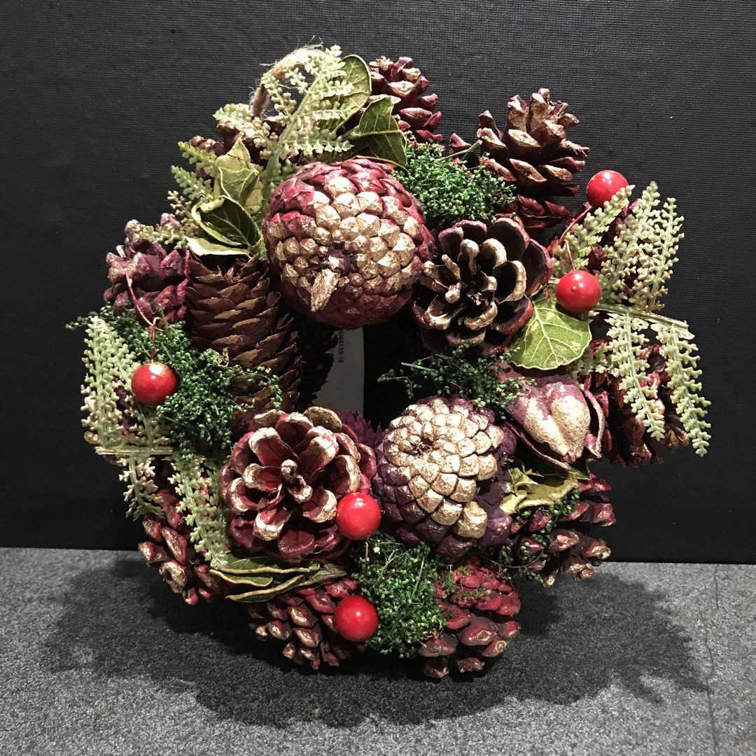 Rustic Christmas wreath with pinecones and red berries (Category: Wall Decor) located in Baao. Submitted by all.things.japan (Listing ID 1465310941, Image 1). Description: 7.0 inches/18 cm diameter - Festive holiday wreath crafted from natural pinecones - Beautiful burgundy and gold dipped tips - Decorated with lush green foliage, moss, and bright red berries - Includes a sturdy cardboard backing with tag attached - Equipped with a jute twine loo