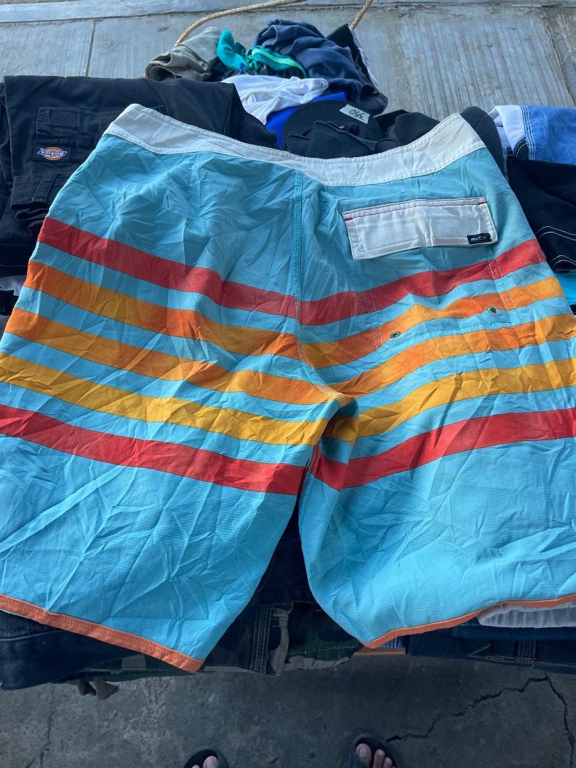RVCA Boardshorts Striped Size 32 (Category: Swim Trunks & Board Shorts) located in Puerto Princesa. Submitted by bestthrift123 (Listing ID 1465257231, Image 2). Description: - Brand: RVCA - Size: 32 - Design: Light blue, orange, and yellow stripes - Material: Performance stretch fabric (94% polyester, 6% spandex) - Features: White waistband with red drawstring, RVCA round logo patch on lower left leg - Origin: Made in China - Condition: Excellent
