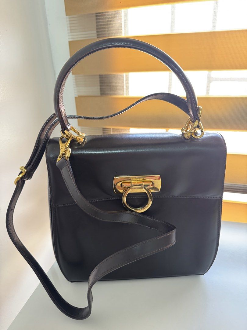 Salvatore Ferragamo Gancini Top Handle Bag (Category: Luxury Bags & Wallets) located in Angeles City. Submitted by thala.1204.68 (Listing ID 1465175980, Image 1). Description: - Brand: Salvatore Ferragamo comes with certificate of authenticity/100% original - very good condition - Material: Premium dark brown leather - Hardware: Gold-tone Gancini hardware with turn-lock closure - Style: Structured boxy vintage design - Versatility: Includes a top