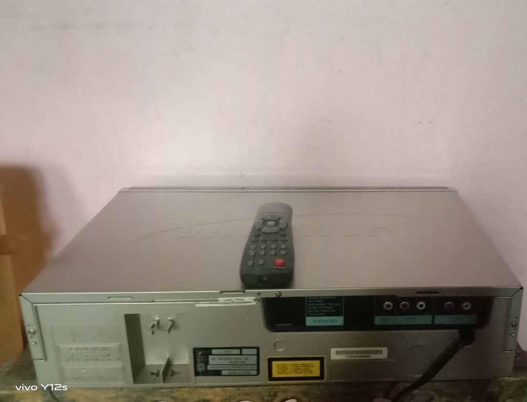 Samsung Silver VCD Player with Remote Control Z 100 S (Category: Blu-Ray & Media Players) located in Caloocan City. Submitted by joanne_therese (Listing ID 1465172291, Image 2). Description: Silver home audio/visual unit with standard RCA ports for easy TV or stereo connection. Includes a matching grey remote control and attached power cord. Features a solid metal housing with rear ventilation. *D makatest ng CD dahil di bumubukas yung tray. Para