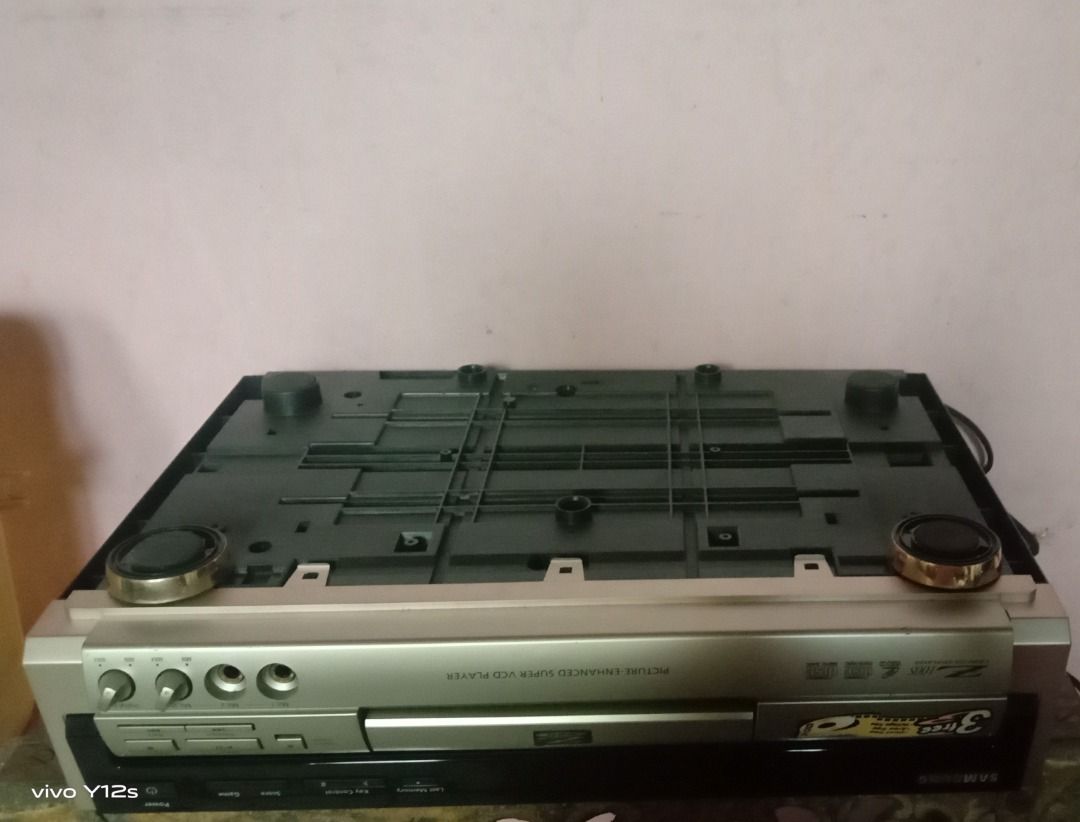 Samsung Silver VCD Player with Remote Control Z 100 S (Category: Blu-Ray & Media Players) located in Caloocan City. Submitted by joanne_therese (Listing ID 1465172291, Image 3). Description: Silver home audio/visual unit with standard RCA ports for easy TV or stereo connection. Includes a matching grey remote control and attached power cord. Features a solid metal housing with rear ventilation. *D makatest ng CD dahil di bumubukas yung tray. Para