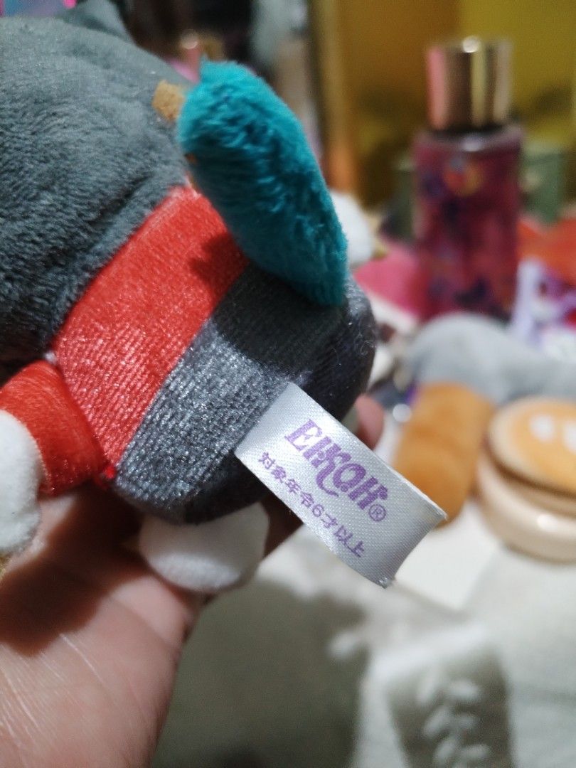 Sanrio Kuromi Eikoh Plush Keychain Strap (Category: Plushies & Soft Toys) located in La Trinidad. Submitted by malditas (Listing ID 1465335532, Image 3). Description: - Brand: Sanrio & Eikoh - Character: Kuromi - Design: Grey jester hat with red ribbons, small skull embroidery, and blue tail detail - Condition: Clean, excellent, no stains or damage - Authenticity: Includes '24 Sanrio and Eikoh tush tag - Features: Red strap attached for easy hang