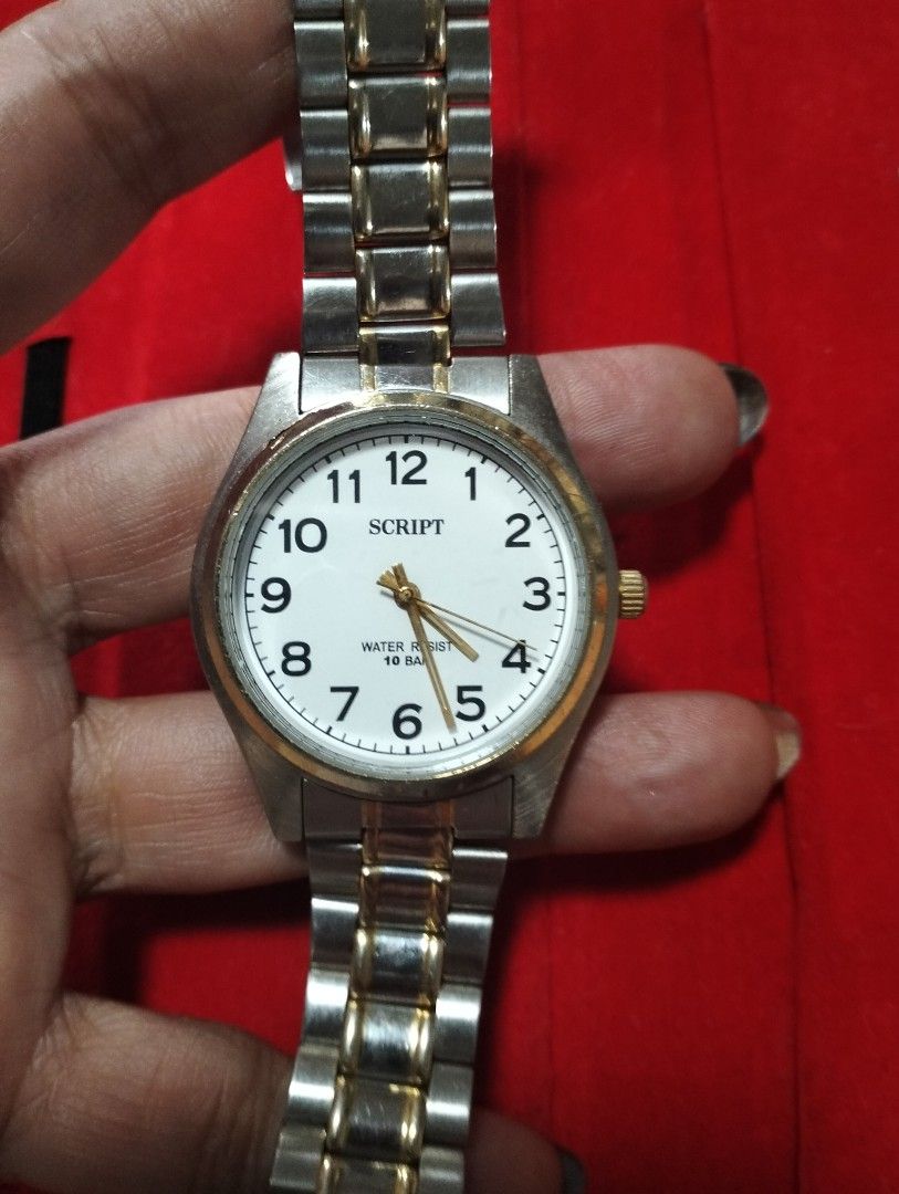 Script Two-Tone Quartz Watch White Dial (Category: Men's Watches) located in General Mariano Alvarez. Submitted by ma.miafajardo1219 (Listing ID 1465373549, Image 3). Description: - Design: Two-tone silver and gold stainless steel bracelet with a gold crown - Dial: White dial featuring clear black Arabic numerals and gold-toned hands - Durability: Water resistant up to 10 bar with a stainless steel back case - Branding: Marked with modern timepie