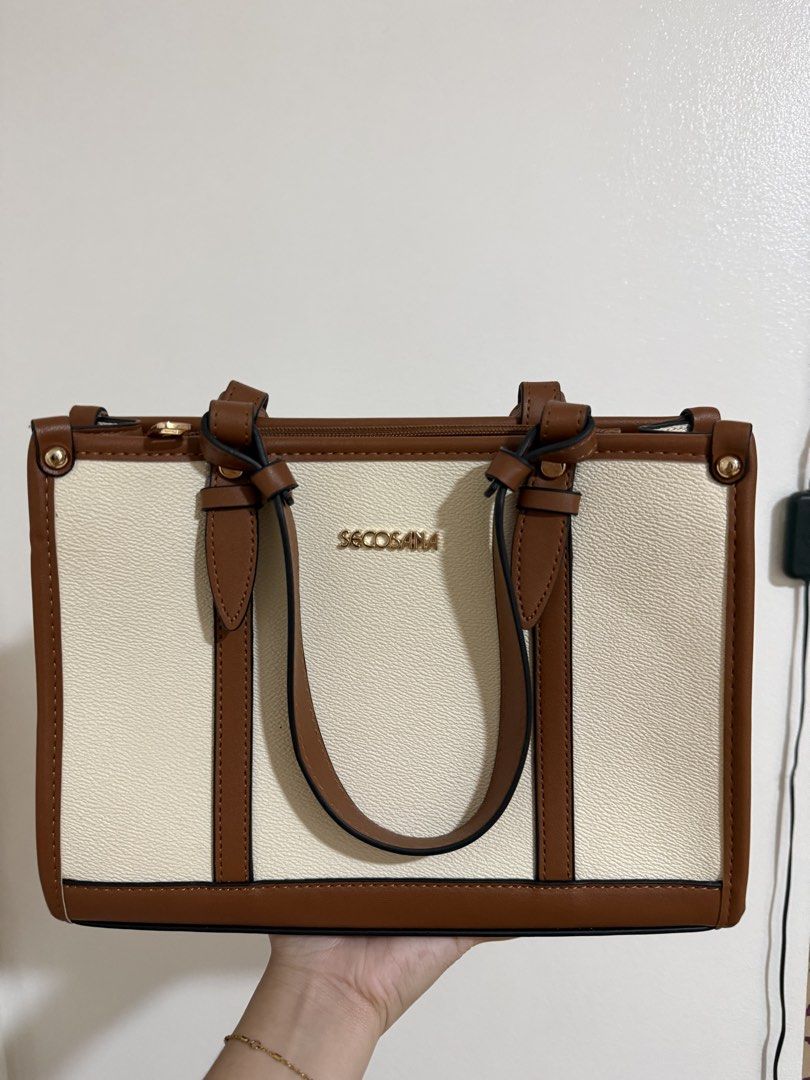 Secosana Two-Tone Shoulder and Tote Bag (Category: Tote Bags) located in Manila. Submitted by miksii_. (Listing ID 1465273170, Image 2). Description: - Brand: Secosana - Material: White and brown faux leather with gold-tone hardware - Design: Structured shape with vertical brown contrast stripes on front and back - Straps: Double top handles and an adjustable, detachable long strap for crossbody wear - Closure: Top zipper closure - Condition: Cle