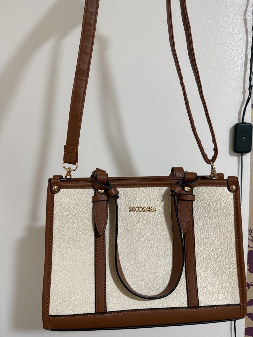 Secosana Two-Tone Shoulder and Tote Bag (Category: Tote Bags) located in Manila. Submitted by miksii_. (Listing ID 1465273170, Image 3). Description: - Brand: Secosana - Material: White and brown faux leather with gold-tone hardware - Design: Structured shape with vertical brown contrast stripes on front and back - Straps: Double top handles and an adjustable, detachable long strap for crossbody wear - Closure: Top zipper closure - Condition: Cle
