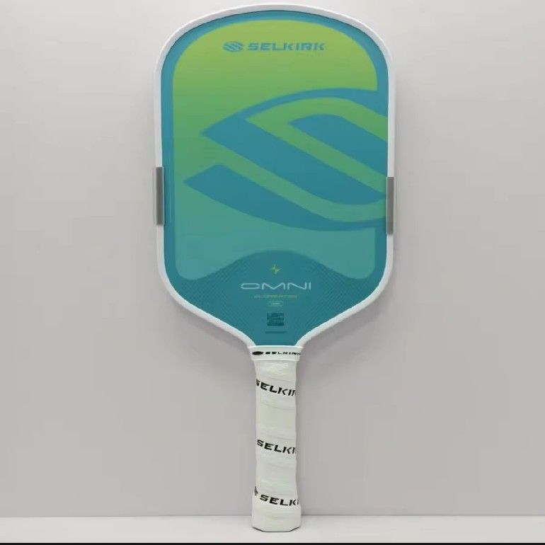 Selkirk Omni Calypso Pickleball Paddle (Category: Racket and Ball Sports) located in Batangas. Submitted by curatedluxxe88 (Listing ID 1465349189, Image 2). Description: - Brand/Model: Selkirk Omni "Calypso" Pickleball Paddle - Shape: Elongated design for extra reach - Aesthetics: Eye-catching green and blue gradient face with large logo - Protection & Grip: White edge guard and comfortable white Selkirk overgrip - Customization: Edge tape weight
