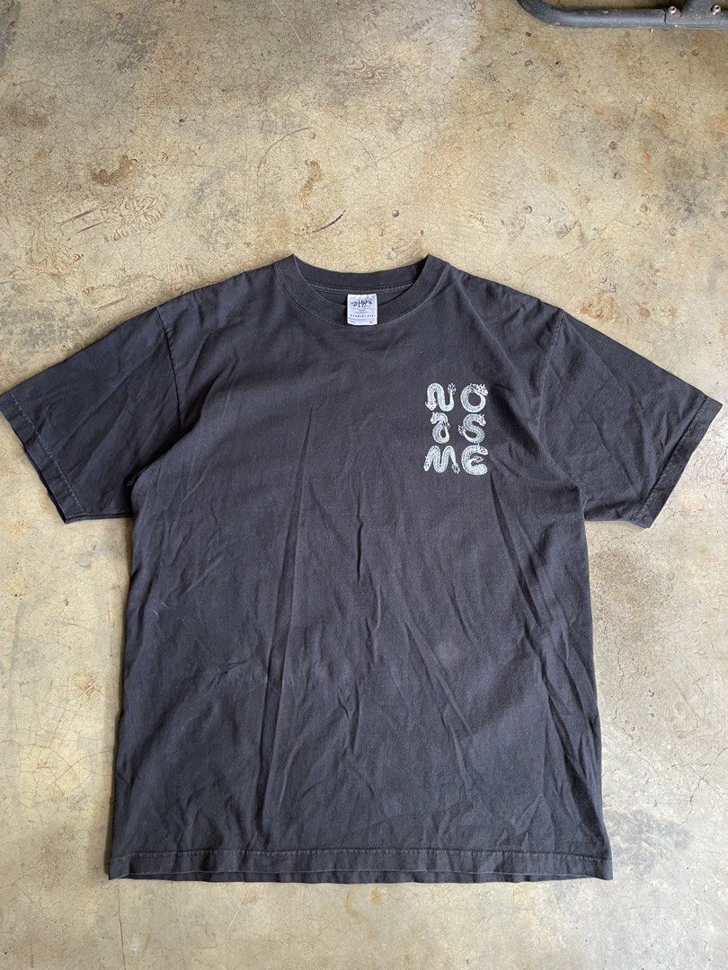 SHAKA WEAR (L) (Category: Activewear) located in Valencia. Submitted by macsss11 (Listing ID 1465192558, Image 2). Description: The image shows a black pigment-dyed t-shirt featuring a white graphic print on the front and a Shaka Wear neck label..