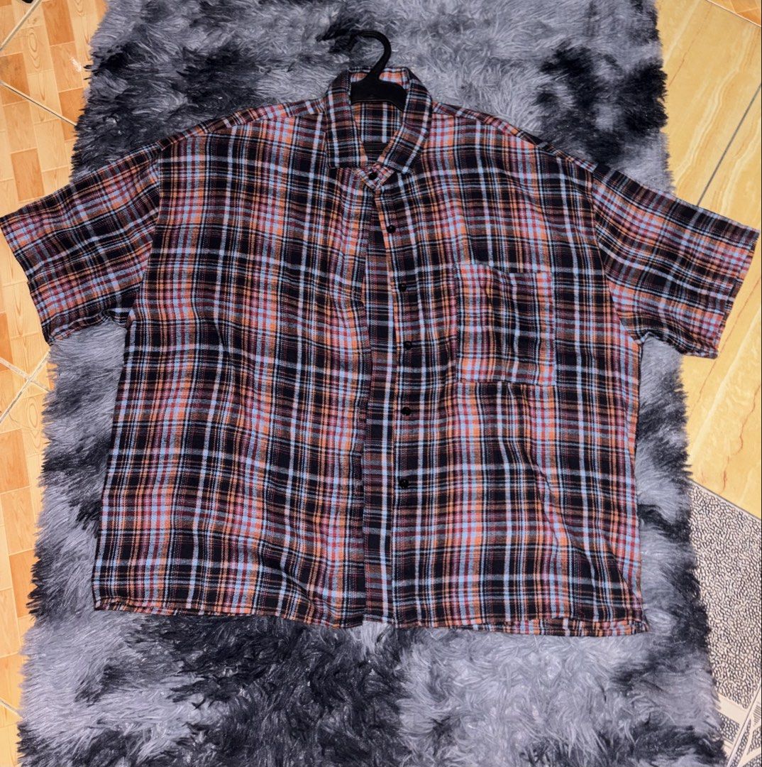 Short sleeve plaid button up shirt (Category: Shirts) located in Manila. Submitted by michellebu59261 (Listing ID 1465195657, Image 1). Description: - Short sleeve button-up shirt in a striking black, orange, and light blue plaid pattern - Classic collared neck with a front button closure - Features a single convenient chest pocket on the left side - Relaxed fit through the body for all-day comfort - Standard hemline and clean fabric texture.