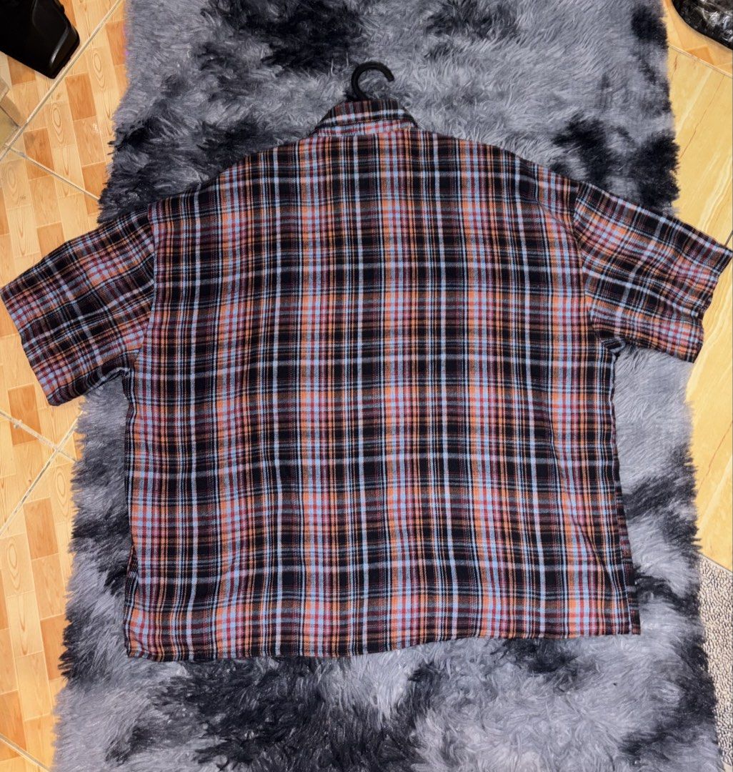 Short sleeve plaid button up shirt (Category: Shirts) located in Manila. Submitted by michellebu59261 (Listing ID 1465195657, Image 2). Description: - Short sleeve button-up shirt in a striking black, orange, and light blue plaid pattern - Classic collared neck with a front button closure - Features a single convenient chest pocket on the left side - Relaxed fit through the body for all-day comfort - Standard hemline and clean fabric texture.