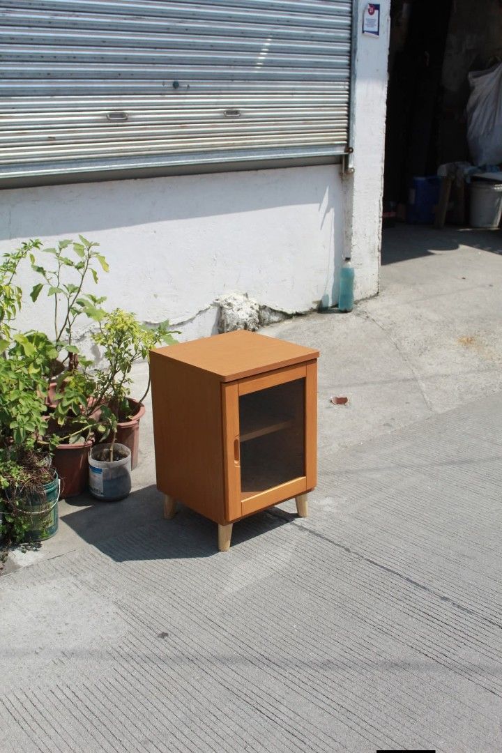 Side Cabinet (Category: Shelves, Cabinets & Racks) located in Meycauayan. Submitted by marygracecasimiro (Listing ID 1465173927, Image 3). Description: Compact Wooden Glass Cabinet Clear glass door, interior shelf, warm honey-cherry finish and tapered wooden legs. Perfect as a bedside table, side cabinet or small storage unit L:15 ¾ • W:15 ¾ • H:24 inches 4,000 pesos only🩷🧡.