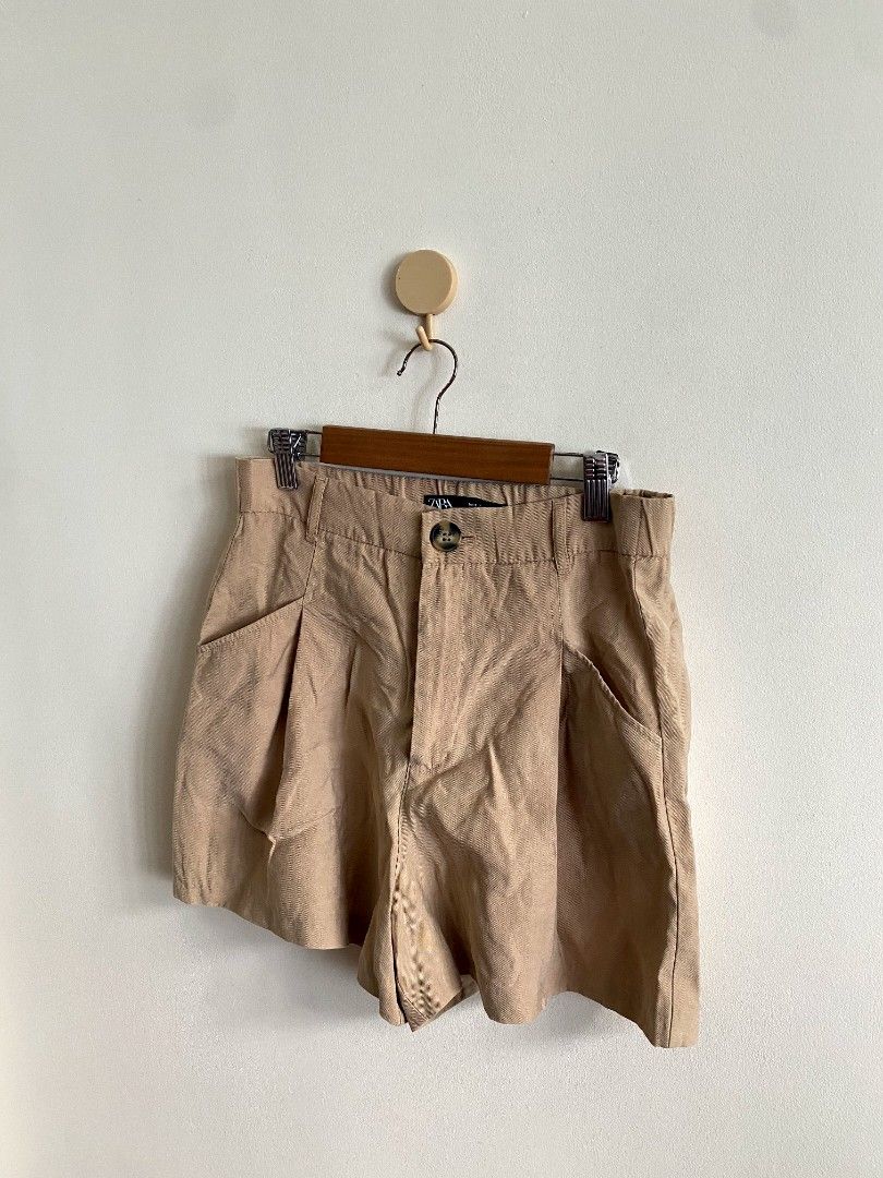 Small Zara High Waist Short (Category: Shorts) located in Castillejos. Submitted by lalainecloset22 (Listing ID 1465238848, Image 3). Description: - Brand: Zara - Size: Small (EUR S / USA S / MEX 26, approx. 14 inches waist flat-lay) - Style: High waist, pleated front design with side pockets - Color: Classic camel / khaki / beige - Condition: Excellent, well-maintained - Versatile piece great for everyday wear, office casual, or weekend gala.