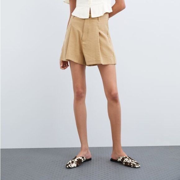 Small Zara High Waist Short (Category: Shorts) located in Castillejos. Submitted by lalainecloset22 (Listing ID 1465238848, Image 1). Description: - Brand: Zara - Size: Small (EUR S / USA S / MEX 26, approx. 14 inches waist flat-lay) - Style: High waist, pleated front design with side pockets - Color: Classic camel / khaki / beige - Condition: Excellent, well-maintained - Versatile piece great for everyday wear, office casual, or weekend gala.