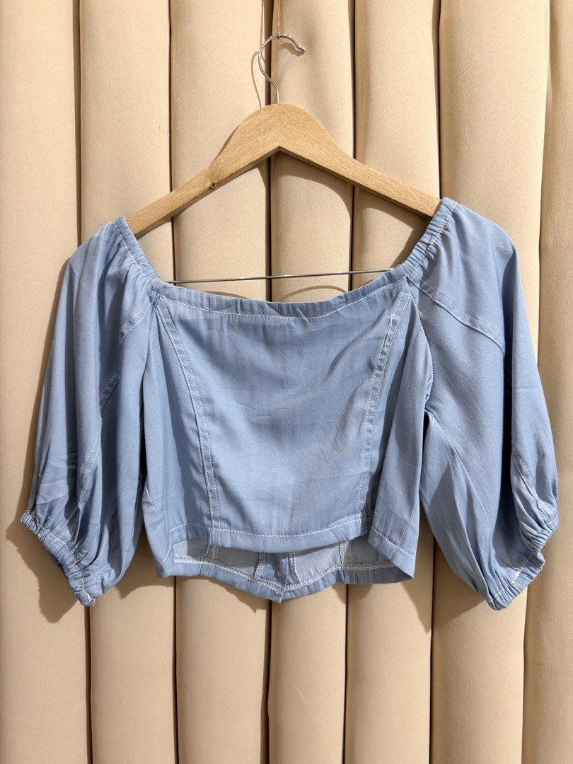 Soft Denim Like Milkmaid Cropped Blouse (Category: Blouses) located in Manila. Submitted by glamstylemnl (Listing ID 1465319202, Image 2). Description: ♡ SIZE: S ♡ BUST: 32 ♡ Swipe left to see the actual color & details ♡ Puff sleeve / front button closure / square neck ♡ HQ • 10/10 ♡ Ready to wear 👚.