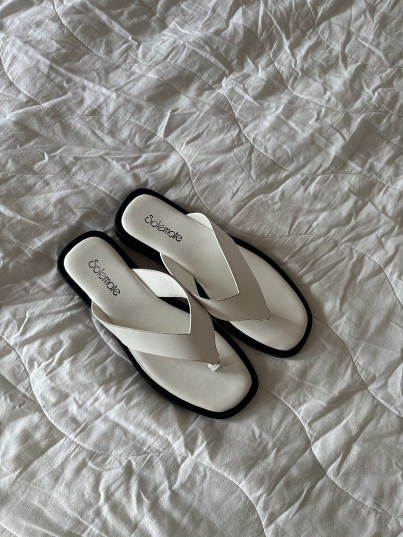 Solemate White Thong Sandals Square Toe (Category: Flats & Sandals) located in Naga. Submitted by maartsy.co (Listing ID 1465271794, Image 2). Description: - Brand: Solemate - Style: Minimalist thong sandals with easy slip-on wear - Design: White upper straps with contrasting black trim and trendy square toe - Condition: Excellent, clean overall with virtually no wear on the soles - Features: Textured tread underneath for added grip.