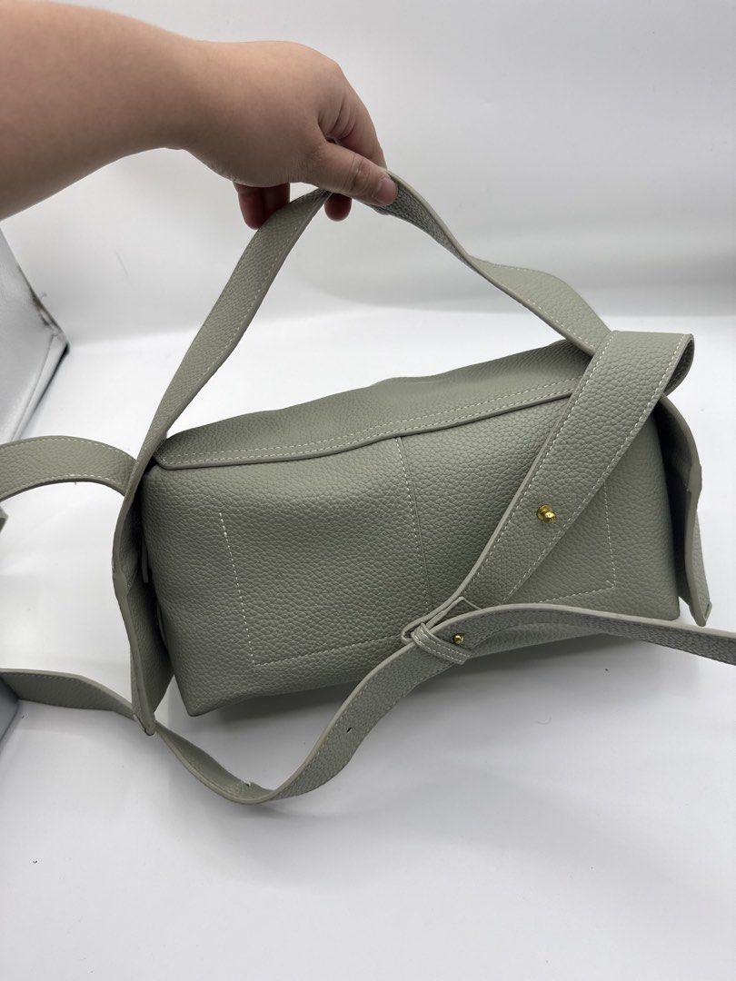 Songmont (Category: Shoulder Bags) located in Caloocan City. Submitted by rossvault2 (Listing ID 1465229374, Image 3). Description: - Brand: Songmont - Color: Sage green with contrast white stitching - Material: Premium pebbled leather - Hardware: Polished gold tone - Features: Structured rectangular shape, front flap closure with branded leather tag, protective metal feet underneath - Straps: Includes both a wide adjustable shoulder strap and a 
