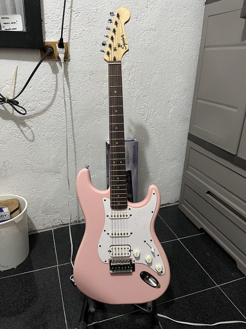 Squier Stratocaster Electric Guitar Pink (Category: Musical Instruments) located in Manila. Submitted by newyolker (Listing ID 1465377191, Image 1). Description: - Pink Squier Stratocaster electric guitar - HSS pickup configuration for versatile tones - Maple neck with rosewood fretboard - Standard tremolo bridge with volume and tone knobs - String action measured and shown in photos using a Fritz ruler.