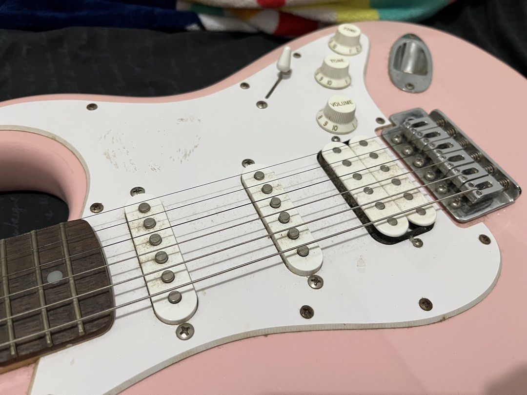 Squier Stratocaster Electric Guitar Pink (Category: Musical Instruments) located in Manila. Submitted by newyolker (Listing ID 1465377191, Image 3). Description: - Pink Squier Stratocaster electric guitar - HSS pickup configuration for versatile tones - Maple neck with rosewood fretboard - Standard tremolo bridge with volume and tone knobs - String action measured and shown in photos using a Fritz ruler.