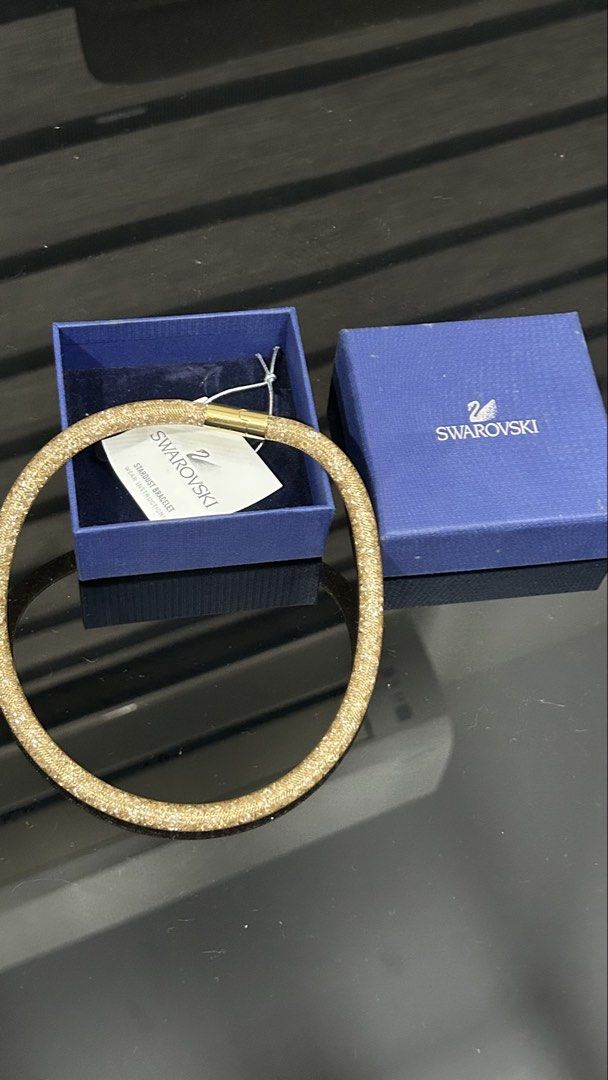 Swarovski Stardust Bracelet Gold (Category: Bracelets) located in San Fernando. Submitted by TheBTBs (Listing ID 1465357751, Image 3). Description: - Authentic Swarovski Stardust bracelet in a stunning gold mesh tube design filled with sparkling crystals - Secure gold-tone metal magnetic closure with a strong snap - Comes complete with the original Swarovski blue gift box and care instruction tag - Versatile statement piece that looks gorgeous wo