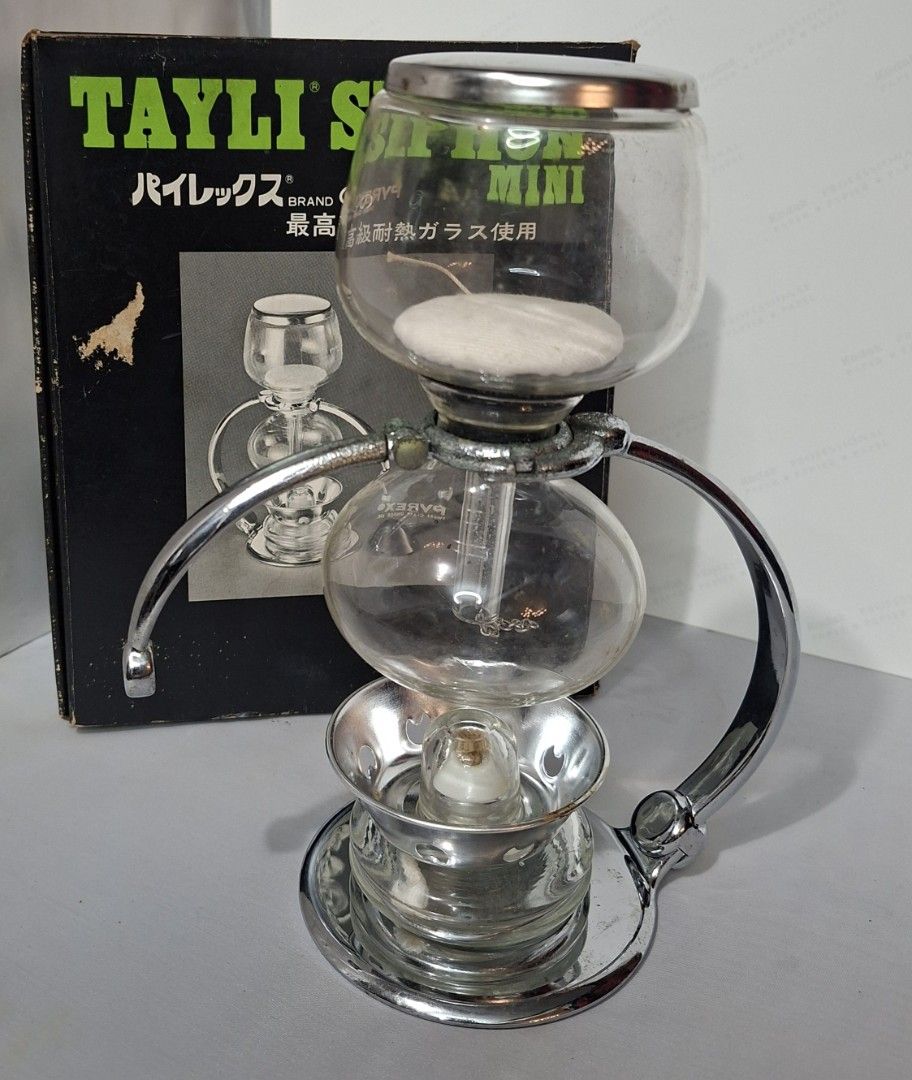Tayli Siphon Mini Coffee Maker (Category: Coffee Machines & Makers) located in Manila. Submitted by glydelmalu86312 (Listing ID 1465309249, Image 3). Description: Tayli Siphon Mini vacuum coffee maker, glass chambers and chrome stand included. Original box included in the back. Burner and cloth filter assembly attached. Vintage piece, shows some tarnishing on the metal hardware from age. Glass is clear and intact. Great collector item for manual 