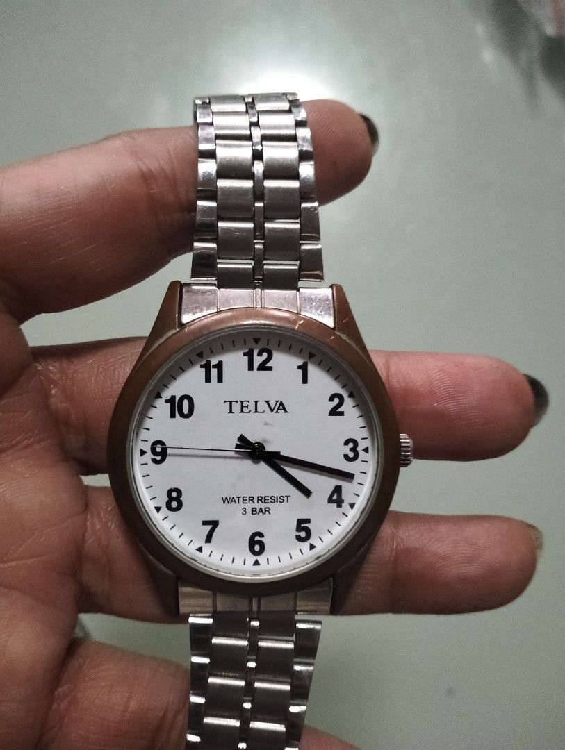 Telva quartz watch with white dial and metal strap (Category: Men's Watches) located in General Mariano Alvarez. Submitted by ma.miafajardo1219 (Listing ID 1465373592, Image 1). Description: - Brand: Telva - Movement: Battery-powered quartz - Dial: Clean white with large, easy-to-read black numbers and a brown bezel rim - Strap: Stainless steel link bracelet with crown on the right - Water Resistance: Up to 3 bar - Condition: Great everyday timep