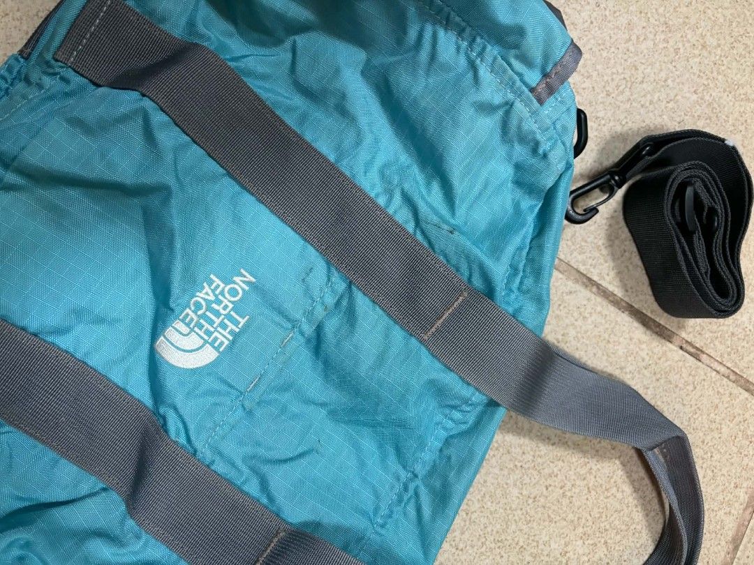 The North Face Cyan Duffle Bag with Strap (Category: Sling Bags) located in Caloocan City. Submitted by joshuadyogi0122 (Listing ID 1465181290, Image 2). Description: - Brand: The North Face - Color: Bright cyan blue with grey webbed handles and logo print - Capacity & Material: 19L nylon - Features: Zip closure with double pulls and matching detachable shoulder strap with clips - Perfect for: Gym trips and short weekend getaways.