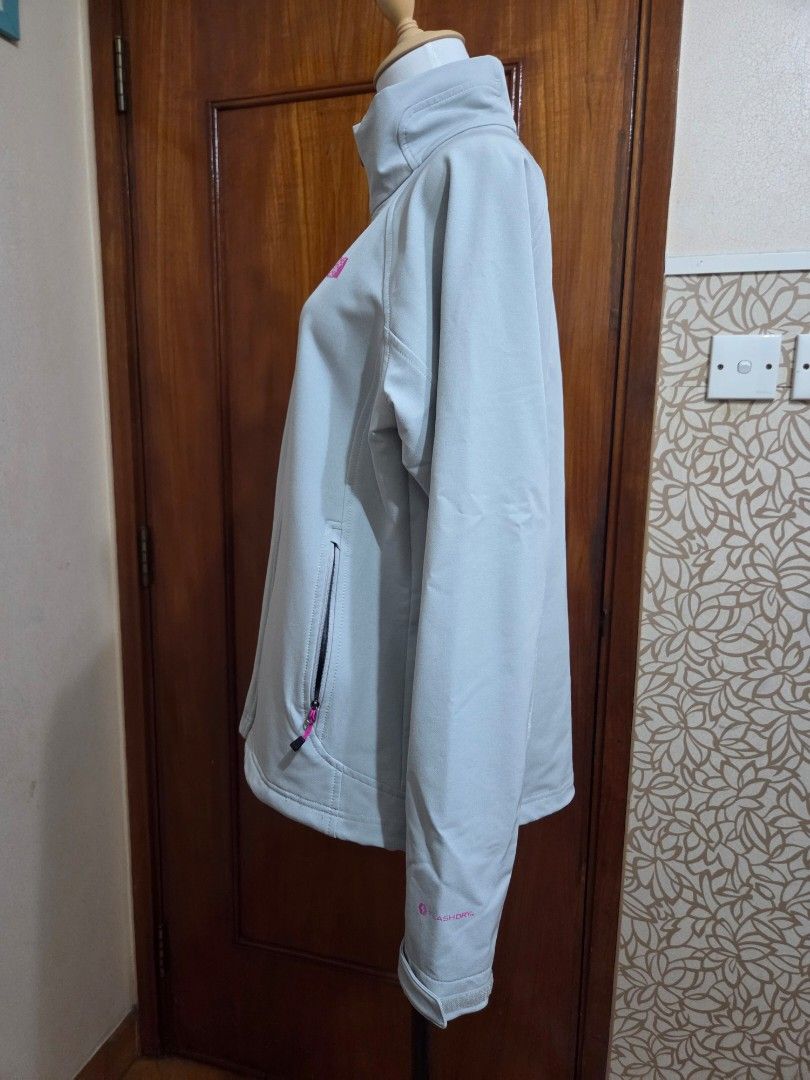 The North Face Light Grey FlashDry Jacket （分類：外套及戶外衣服）位於 Hong Kong。 由 starglitz 提交（商品編號 1465289178，圖片 4）。簡介： Light grey softshell jacket from The North Face. Pink logo on the front chest and back shoulder. FlashDry technology fabric on the sleeve. Full zip closure, two zippered hand pockets with pink pull cords. Adjustable cuffs with velcro straps. Clean look, casual outdoor wear. Never worn. Excellent condition. Washed。