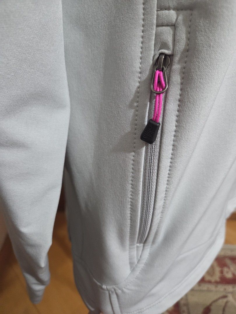 The North Face Light Grey FlashDry Jacket （分類：外套及戶外衣服）位於 Hong Kong。 由 starglitz 提交（商品編號 1465289178，圖片 7）。簡介： Light grey softshell jacket from The North Face. Pink logo on the front chest and back shoulder. FlashDry technology fabric on the sleeve. Full zip closure, two zippered hand pockets with pink pull cords. Adjustable cuffs with velcro straps. Clean look, casual outdoor wear. Never worn. Excellent condition. Washed。