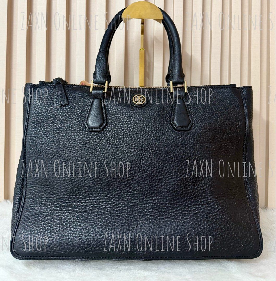 Tory Burch Black Pure Leather Tote Bag (Category: Luxury Bags & Wallets) located in Santa Cruz. Submitted by za2011za (Listing ID 1465317884, Image 1). Description: - Brand: Tory Burch - Material: Premium black pebbled leather - Hardware: Gold-toned with circular logo plaque - Closure: Secure top-zip closure - Design: Structured rectangular shape with dual top handles - Capacity: Spacious interior, ideal for daily essentials and work carryall - C