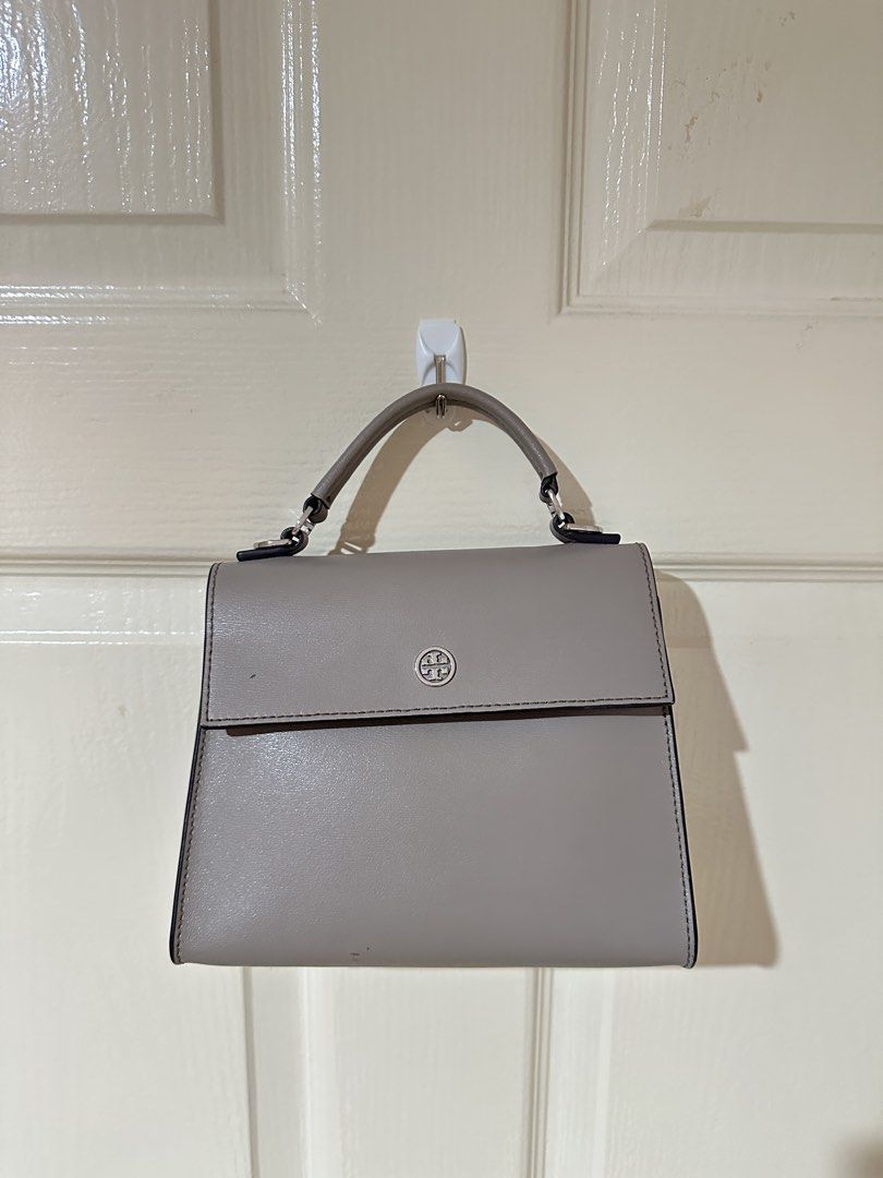 Tory Burch grey leather top handle bag (Category: Luxury Bags & Wallets) located in Manila. Submitted by ktyyycloset (Listing ID 1465333046, Image 1). Description: - Brand: Tory Burch - Color: Classic Neutral Grey - Material: Premium Leather - Style: Structured top handle bag with front flap closure and silver-tone hardware - Perfect for daily outfits and effortless styling -check photos for the condition -with long strap (good condition) .