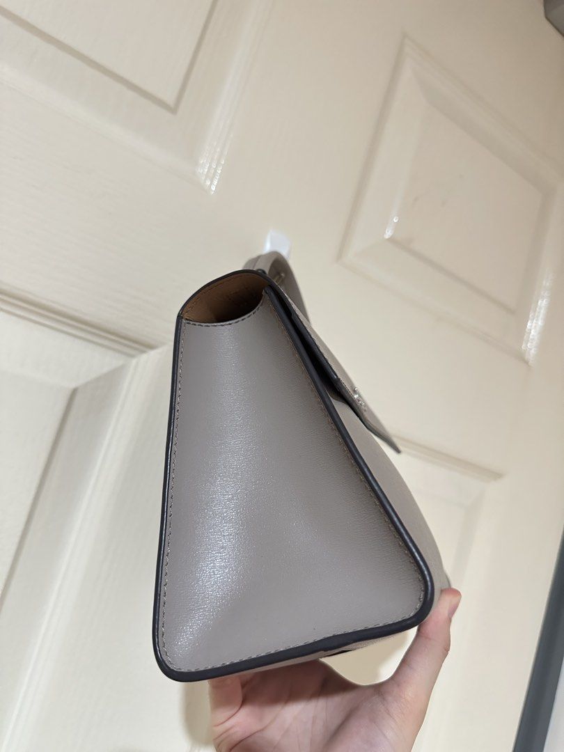 Tory Burch grey leather top handle bag (Category: Luxury Bags & Wallets) located in Manila. Submitted by ktyyycloset (Listing ID 1465333046, Image 3). Description: - Brand: Tory Burch - Color: Classic Neutral Grey - Material: Premium Leather - Style: Structured top handle bag with front flap closure and silver-tone hardware - Perfect for daily outfits and effortless styling -check photos for the condition -with long strap (good condition) .