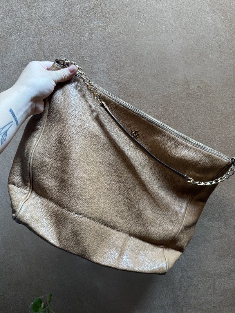 Tory Burch Pebble Leather Shoulder Bag Beige (Category: Luxury Bags & Wallets) located in Bacoor. Submitted by nicafindssince2022 (Listing ID 1465265188, Image 2). Description: - Tory Burch beige pebble leather handbag - Elegant gold-tone hardware with chain strap detail - Secure zip-top closure and structured base - Features small metal logo emblem on the front - Soft, slouchy body that easily fits daily essentials - EUC, clean interior and exte