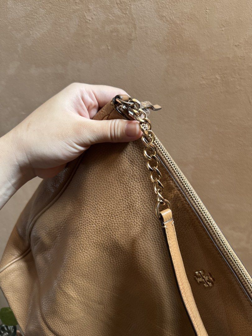 Tory Burch Pebble Leather Shoulder Bag Beige (Category: Luxury Bags & Wallets) located in Bacoor. Submitted by nicafindssince2022 (Listing ID 1465265188, Image 3). Description: - Tory Burch beige pebble leather handbag - Elegant gold-tone hardware with chain strap detail - Secure zip-top closure and structured base - Features small metal logo emblem on the front - Soft, slouchy body that easily fits daily essentials - EUC, clean interior and exte