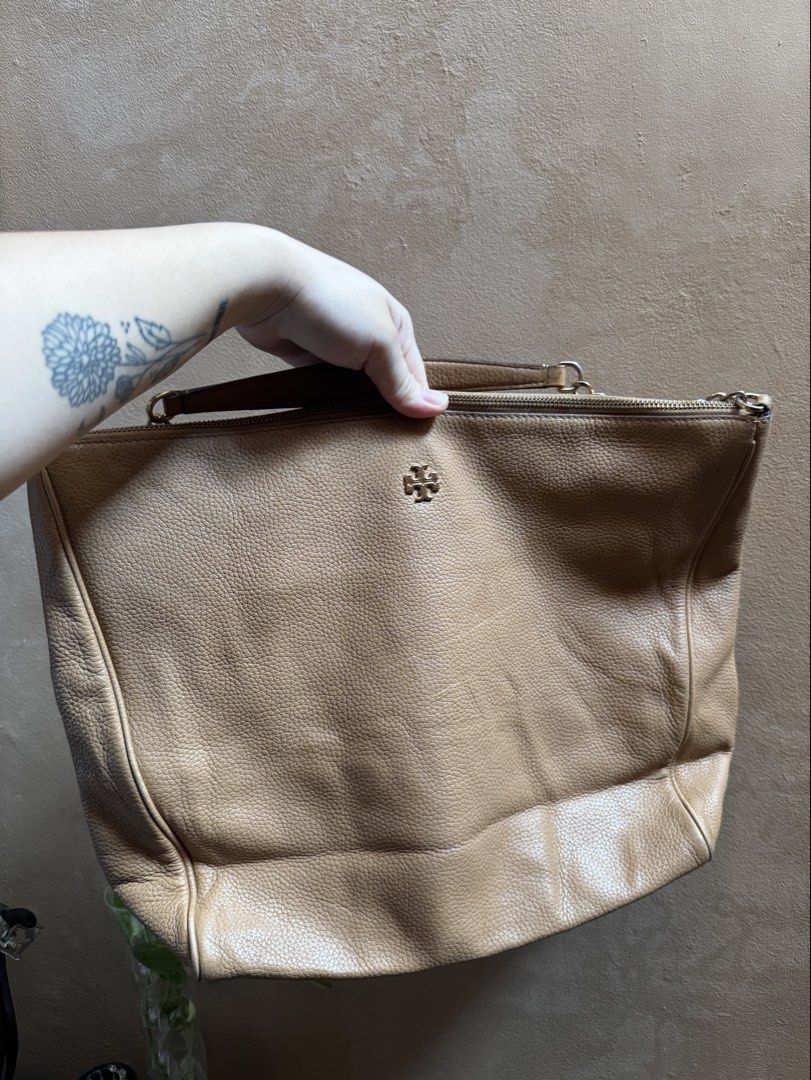Tory Burch Pebble Leather Shoulder Bag Beige (Category: Luxury Bags & Wallets) located in Bacoor. Submitted by nicafindssince2022 (Listing ID 1465265188, Image 1). Description: - Tory Burch beige pebble leather handbag - Elegant gold-tone hardware with chain strap detail - Secure zip-top closure and structured base - Features small metal logo emblem on the front - Soft, slouchy body that easily fits daily essentials - EUC, clean interior and exte